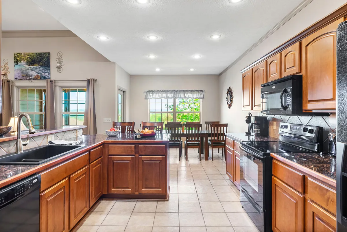 This photo showcases a kitchen island and dining table set near a large window, inviting plenty of natural light into the space. The arrangement highlights opportunities for meal preparation, casual dining, and socializing, with enough space for family or friends to gather and interact while cooking or enjoying meals together.